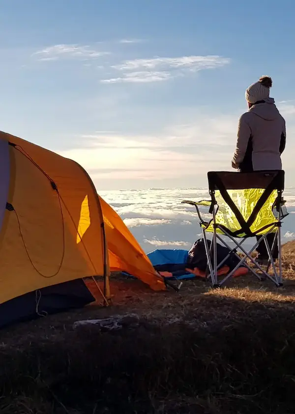 A person at sunrise overlooking a dense sea of clouds in the Santu highlands, Cusco region, Peru