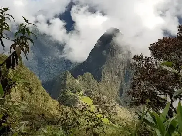 Rear panoramic view of Machu Picchu surrounded by green mountains in Peru