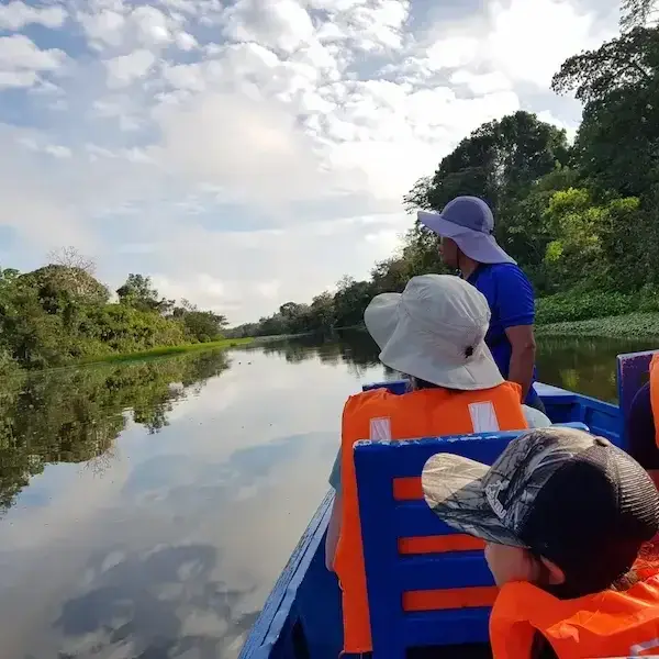 Boat expedition through Amazon rainforest river surrounded by tropical nature