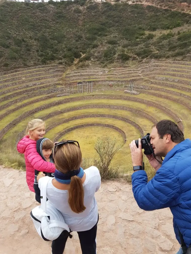 Family taking photos at Moray archaeological site in the Sacred Valley, Peru