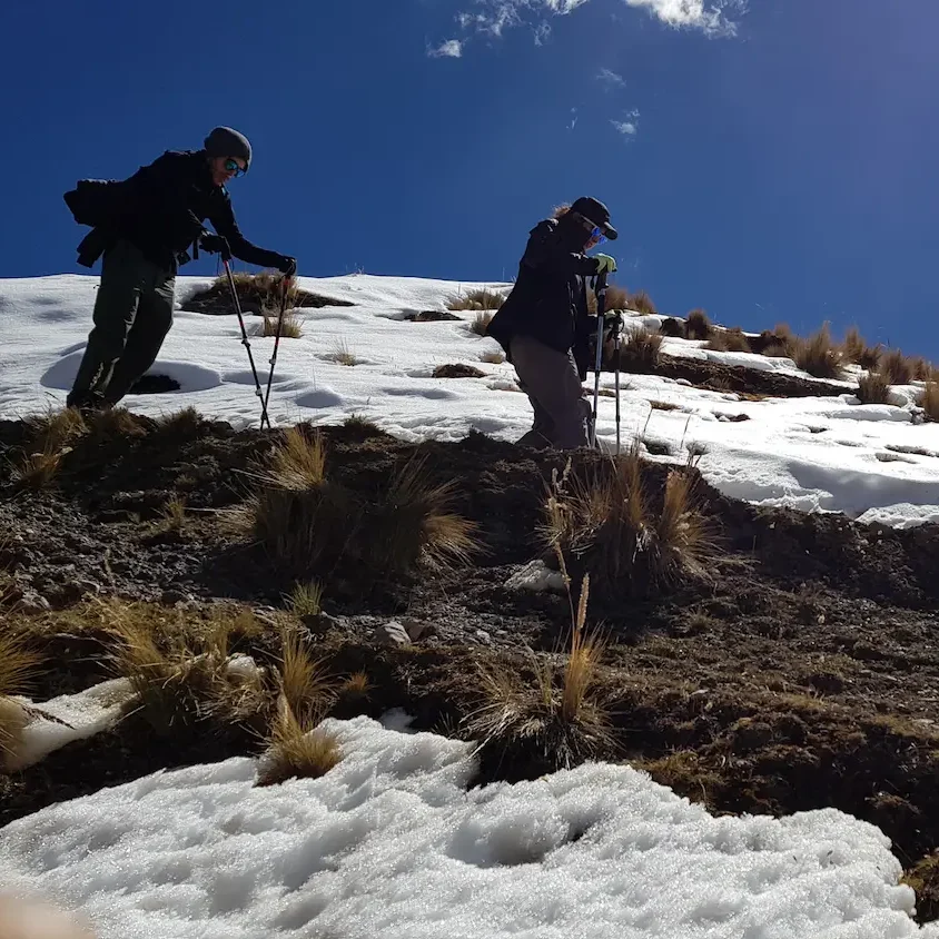 Two hikers crossing a snowy slope in the Cordillera Blanca near Huaraz
