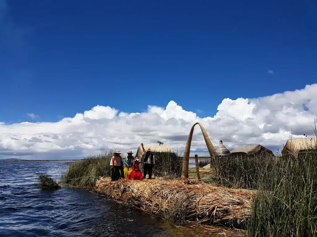 Arrival at the Uros Floating Islands on Lake Titicaca with local people welcoming visitors